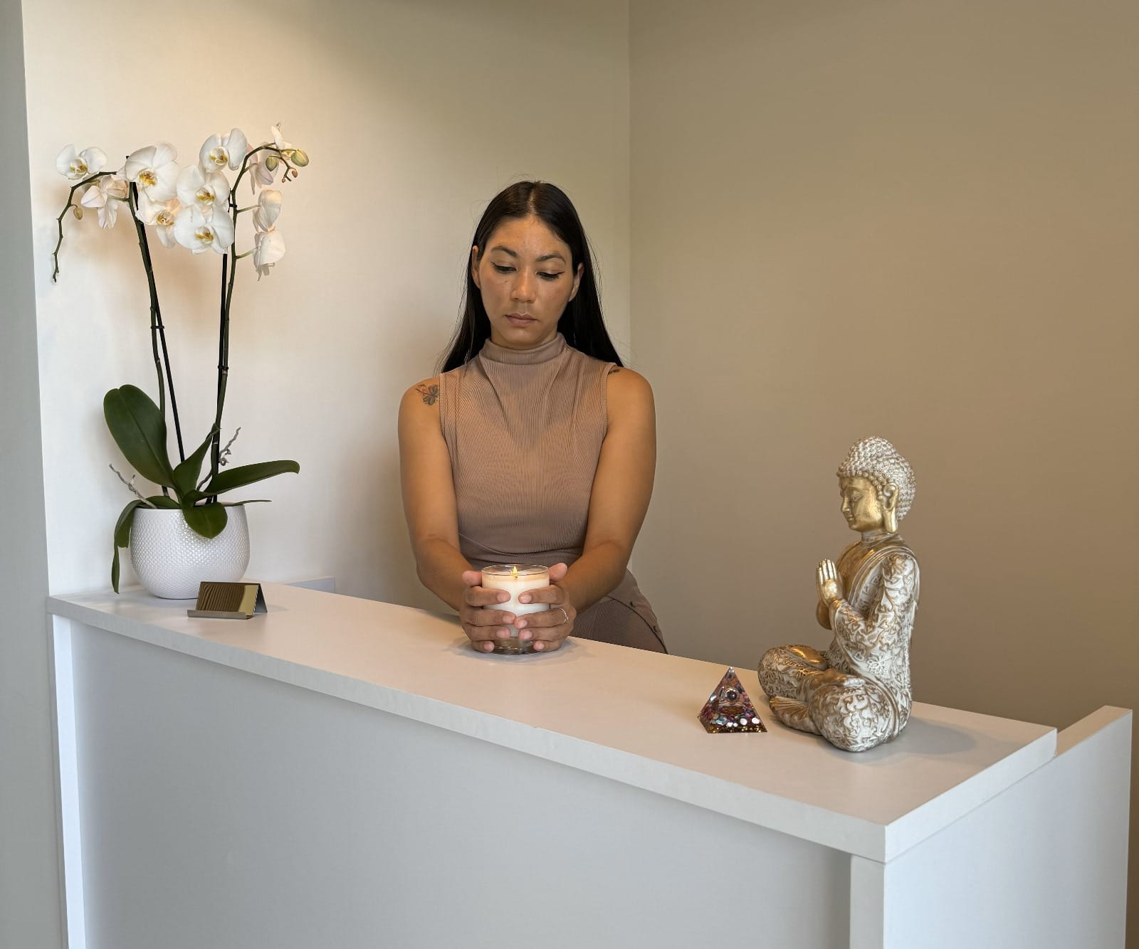 Heidy en la recepción de Sandora junto a una orquídea y una figura de Buda